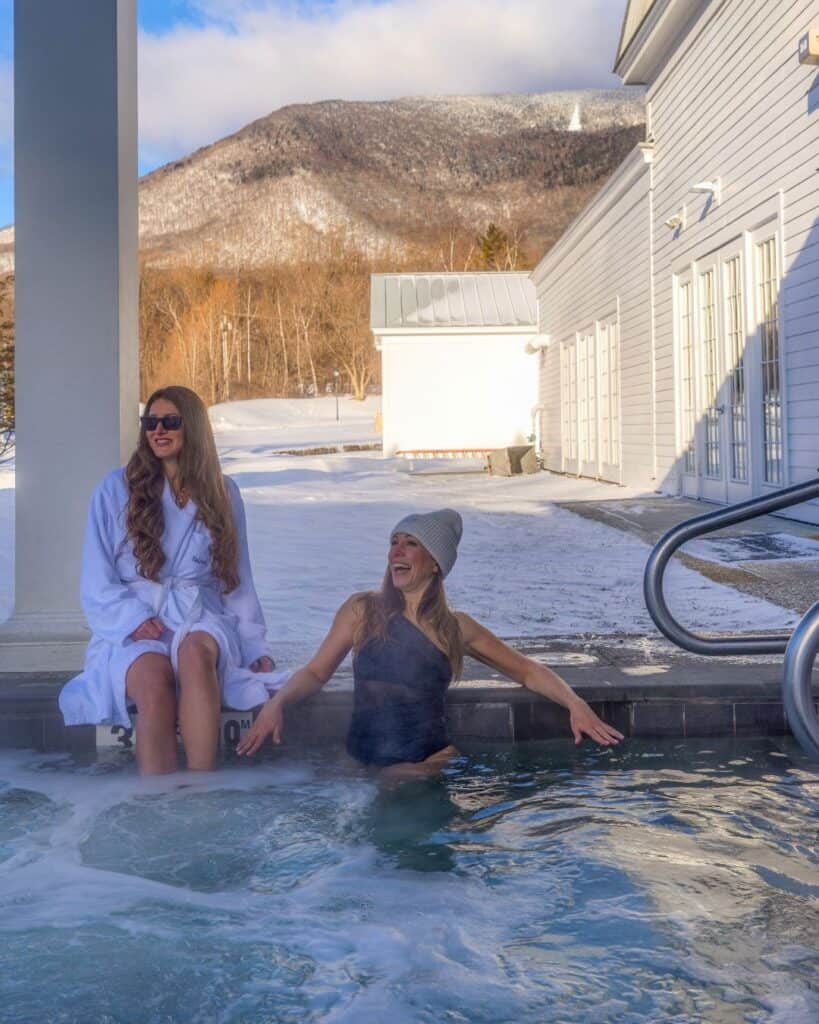 Laura and her friend relaxing in an outdoor hot tub at The Equinox Resort Spa in Manchester Vermont with mountain views