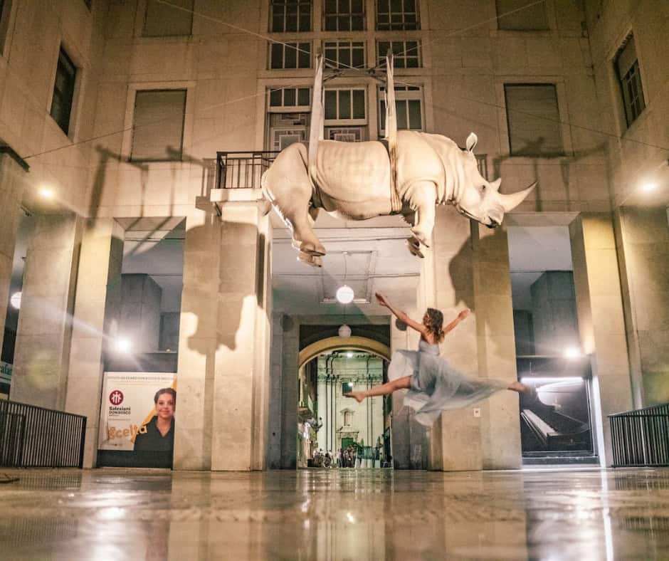 Tempo Sospeso rhino sculpture by Stefano Bombardieri floating in Piazza della Vittoria Brescia Italy at night