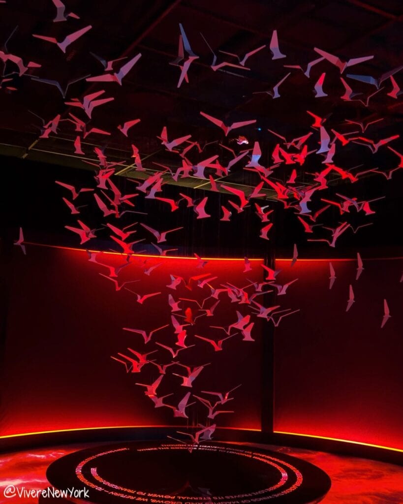 Red room with bird-shaped installation symbolising unconditional love in CHROMA: Tales Between Hues at Genesis House NYC.