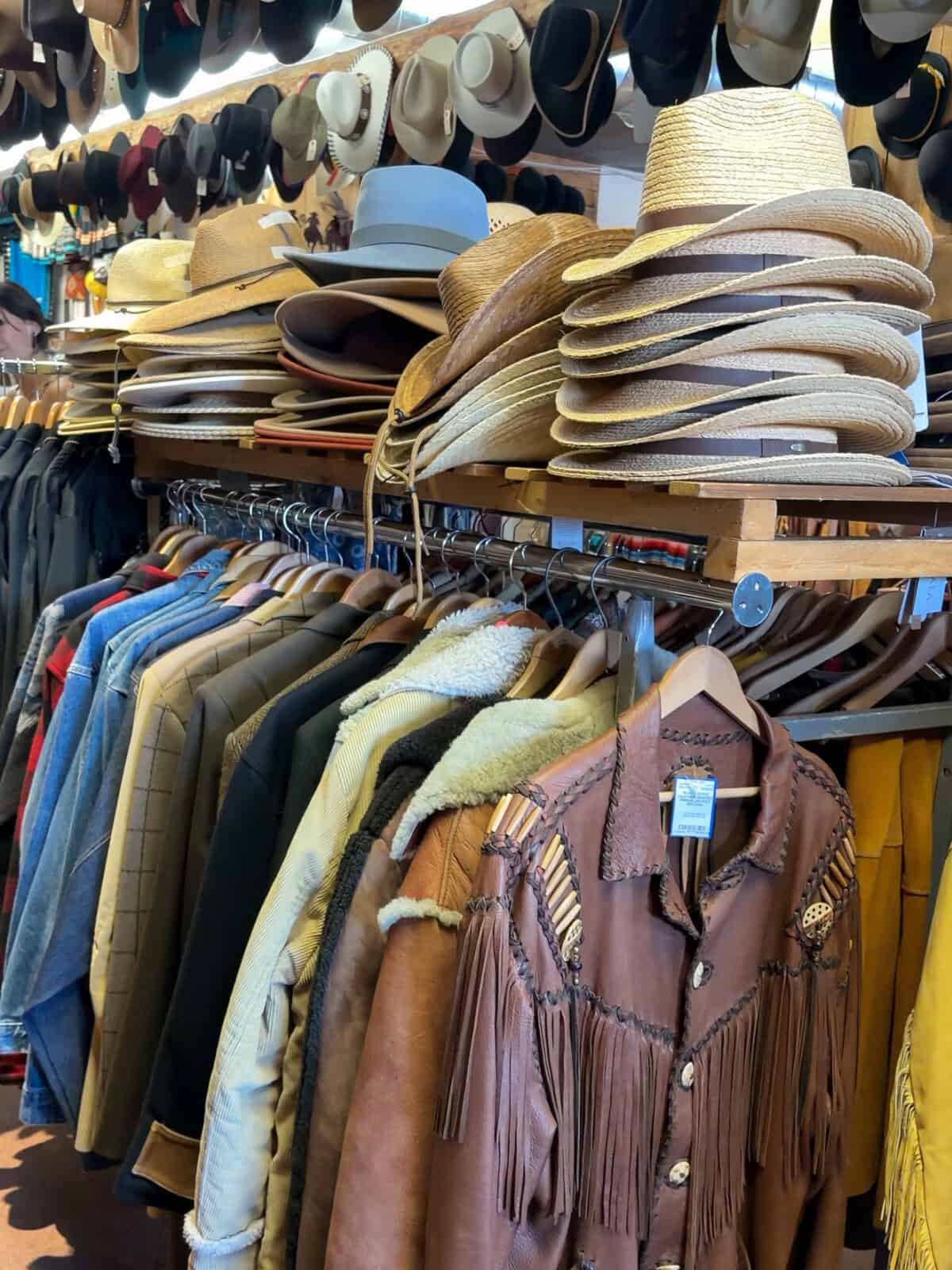 Racks of cowboy hats, leather fringe jackets and vintage western wear inside the Double Take shop in Santa Fe
