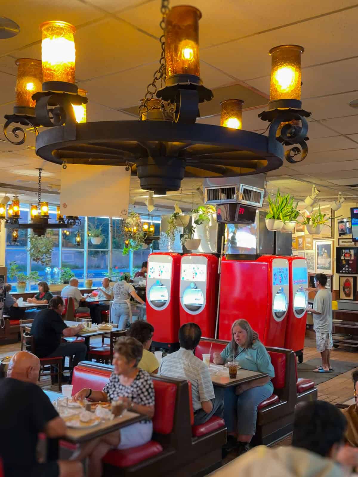 The retro interior of the Frontier Restaurant in Albuquerque, with wagon-wheel chandeliers and red booths along Route 66