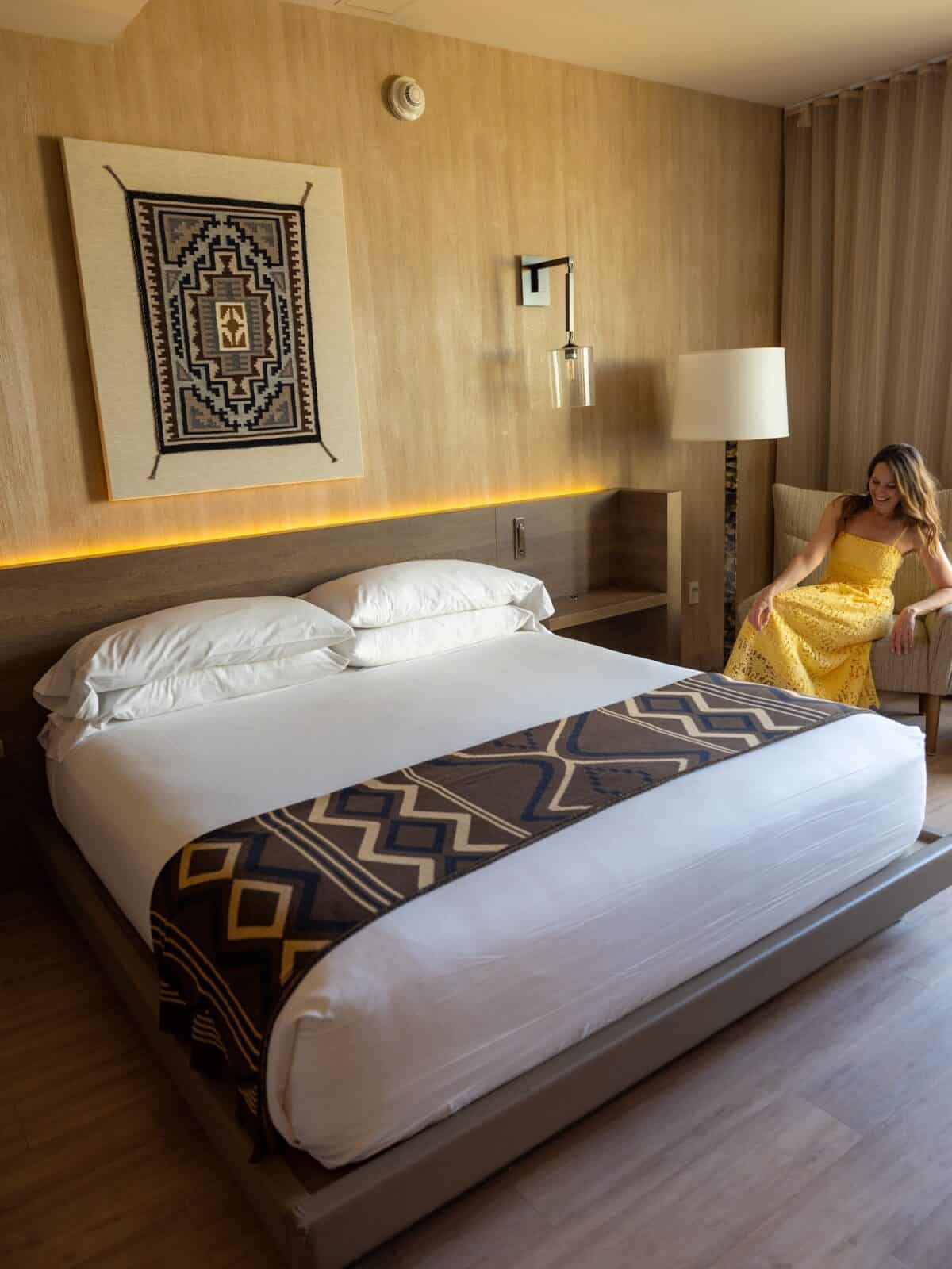 Laura in a Hotel Chaco's room, with a Navajo weaving above the bed, in Albuquerque
