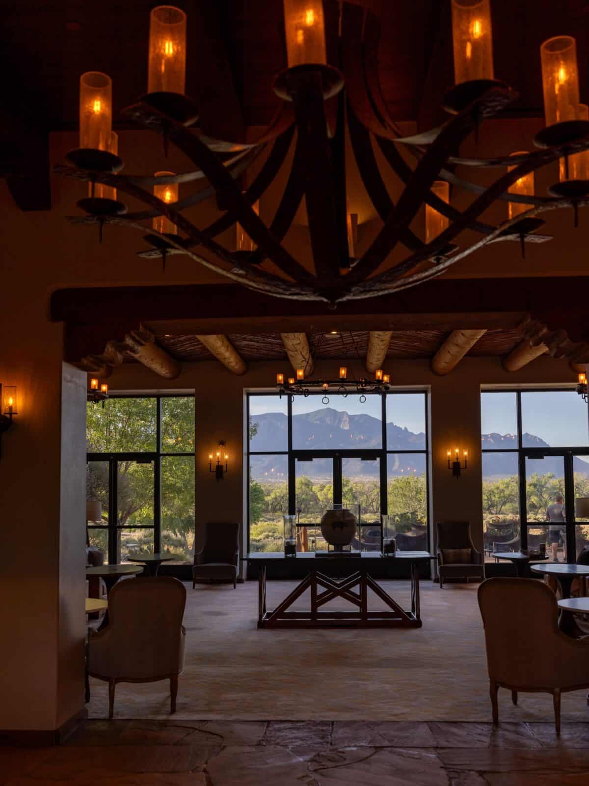 Candlelit chandelier in the Hyatt Regency Tamaya lobby framing the Sandia Mountains through tall windows