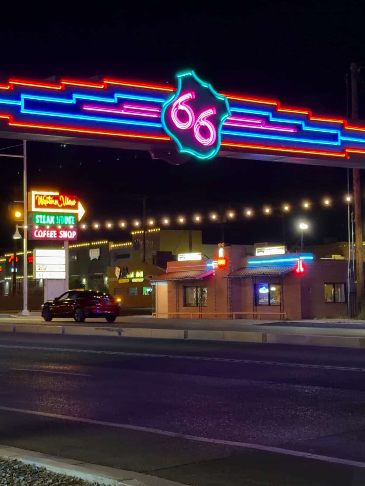 The historic Route 66 neon archway glowing over Central Avenue in Albuquerque at night