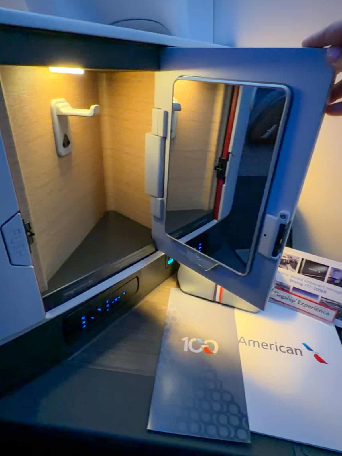 Open vanity cabinet with mirror and storage inside the American Airlines Flagship Suite
