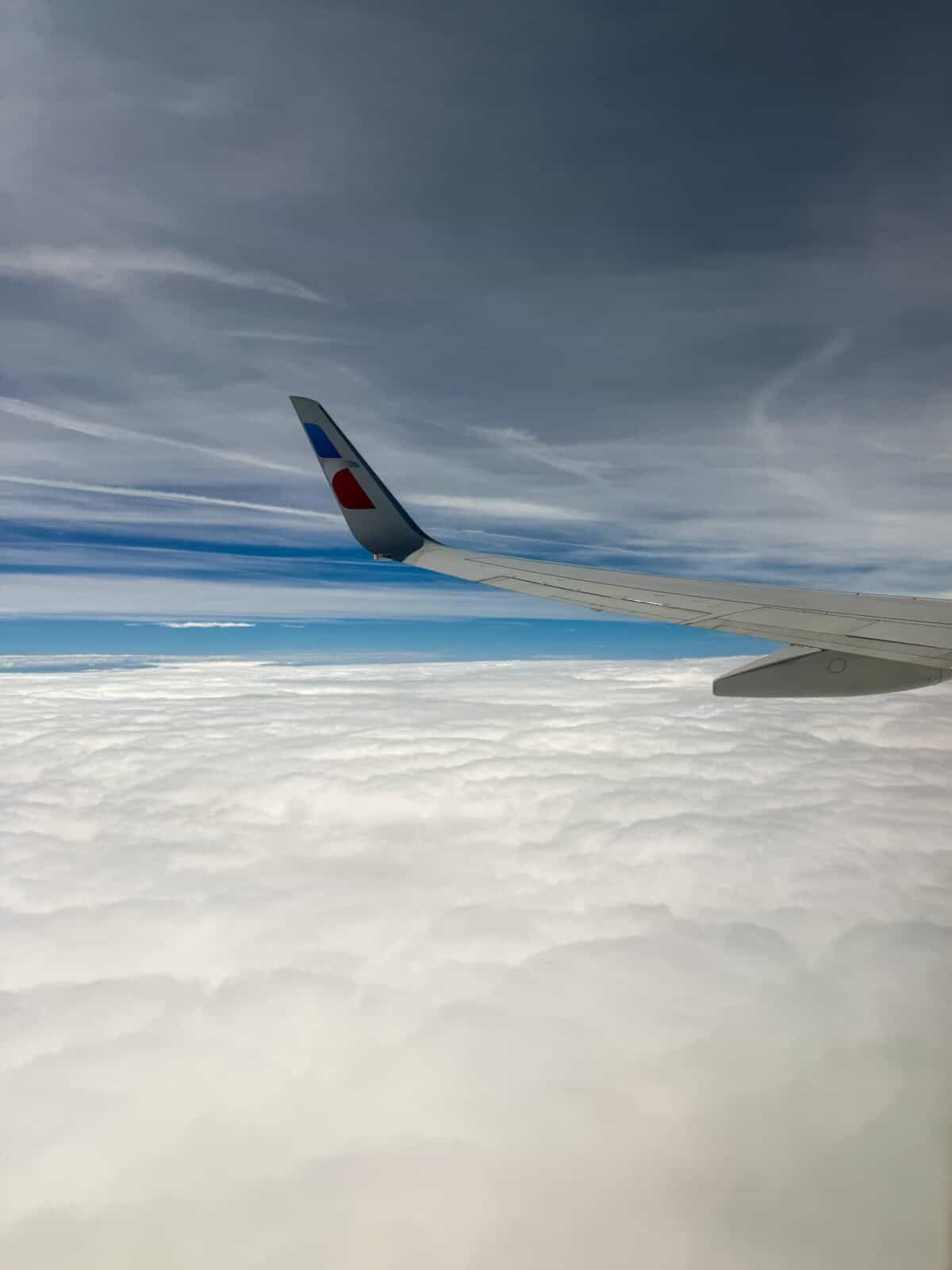 American Airlines wing above the clouds during a flight from New York to Dallas